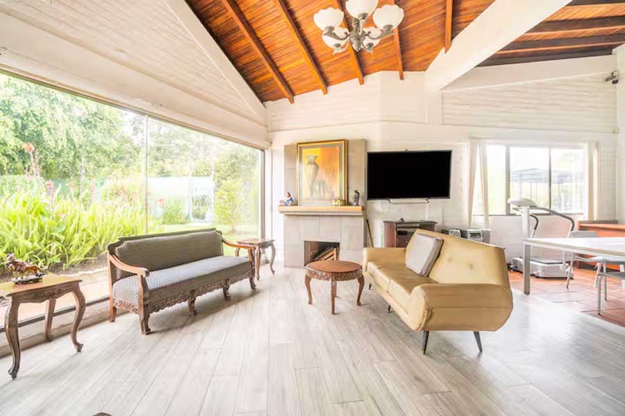 Sala principal de la residencia abierta hacia el jardín